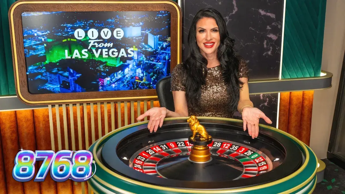 Pemain menggunakan aplikasi kasino di perangkat seluler dengan latar belakang meja kasino Las Vegas.